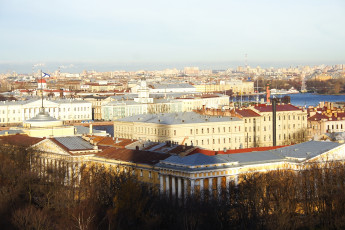 An Aerial View Of St. Petersburg, A Historic Cityscape With Classical Architecture, Featuring Sprawling Buildings With Colorful Roofs Under A Clear Blue Sky, Highlighting The Grandeur Of An Old European City.