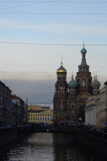 A Tranquil Evening View Of The Griboedov Canal With The Ornate Church Of The Savior On Spilled Blood In The Backdrop, Showcasing Its Distinctive Onion Domes And Intricate Architecture, In St.