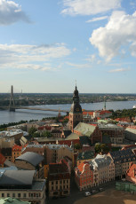 Aerial View Of Riga Showcasing A Blue Sky Littered With White Clouds.