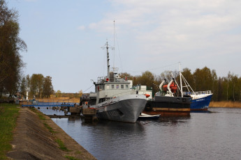 A Daugavgrīva Boat Docked In A Body Of Water.