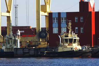 A Voleri Boat Docked Next To A Red Building.
