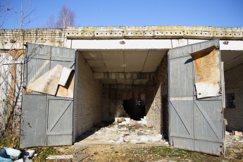 An Abandoned Skulte Building With A Broken Door.
