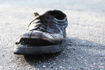 A Black Skulte Shoe On The Ground.
