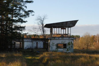 An Abandoned Skulte Building In The Middle Of A Field.