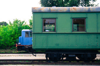 Two Green Train Cars Parked Next To Each Other At A Train Museum.