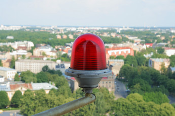 A Red Light On Top Of A Pole Seen From Riga.