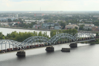 A Picturesque Bridge Spanning Over A River, Offering Breathtaking Views Of Riga From Above.