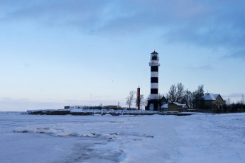 A Frozen Lake With A Lighthouse In Daugavgrīva During Winter.