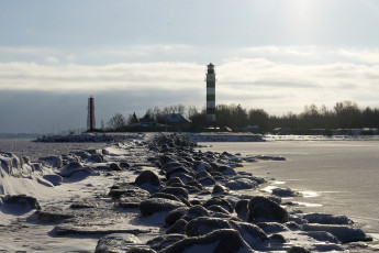 A Frozen Lake With A Lighthouse In Daugavgrīva During Winter.