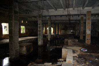 A Iļģuciems Room With A Dirty Floor And A Puddle Of Water.
