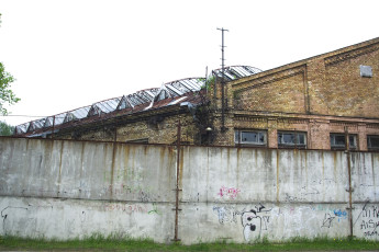 A Graffiti-Covered Brick Building In Iļģuciems.