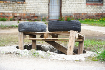 Two Tires Sitting On Top Of A Wooden Bench In Iļģuciems.