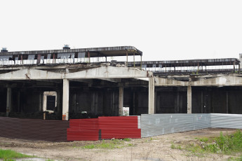 An Abandoned Building In Iļģuciems With A Red And White Fence.