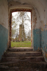 A Doorway In The Old Daugavgrīva Building With A Tower In The Background.