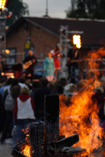 A Group Of People Gathered Around A Bonfire At Dzelzs Vilks Ielīgo '09.