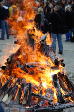A Massive Bonfire Ignites Amid A Bustling Crowd.
